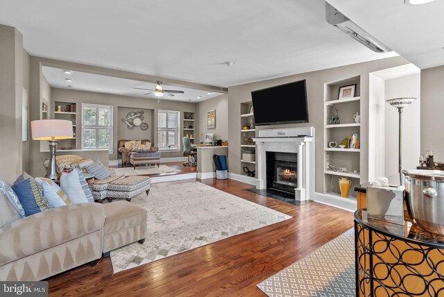 1518 Mount Vernon St Unit 3, Philadelphia, PA 19130 - living room with built in shelves, wood finished floors, ceiling fan, and a fireplace with flush hearth