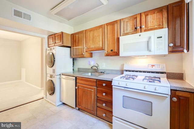 53 Skyhill Rd Unit 204, Alexandria, VA 22314 - kitchen with white appliances, stacked washer and clothes dryer, brown cabinets, and light countertops