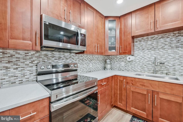 6614 Mccahill Dr, Laurel, MD 20707 - kitchen featuring stainless steel appliances, light countertops, glass insert cabinets, brown cabinetry, and recessed lighting