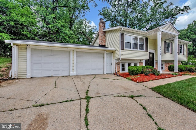 6614 Mccahill Dr, Laurel, MD 20707 - view of front of property with a chimney, brick siding, concrete driveway, and a garage