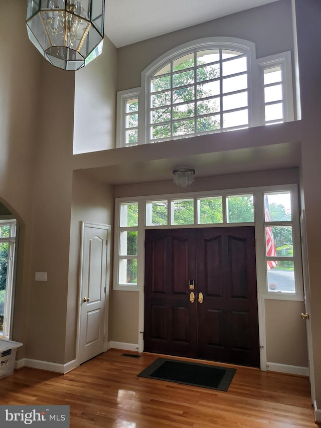 12024 Walnut Branch Rd, Reston, VA 20194 - entrance foyer with a high ceiling, wood finished floors, healthy amount of natural light, arched walkways, and a chandelier