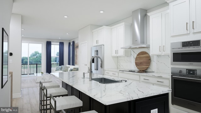 2664 River Birch Rd, Herndon, VA 20171 - kitchen featuring wall chimney range hood, stainless steel double oven, backsplash, white cabinetry, and a kitchen island with sink