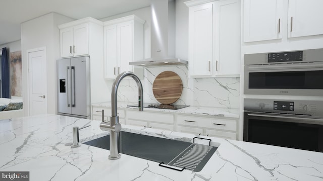 2664 River Birch Rd, Herndon, VA 20171 - kitchen featuring wall chimney range hood, appliances with stainless steel finishes, backsplash, white cabinetry, and light stone countertops