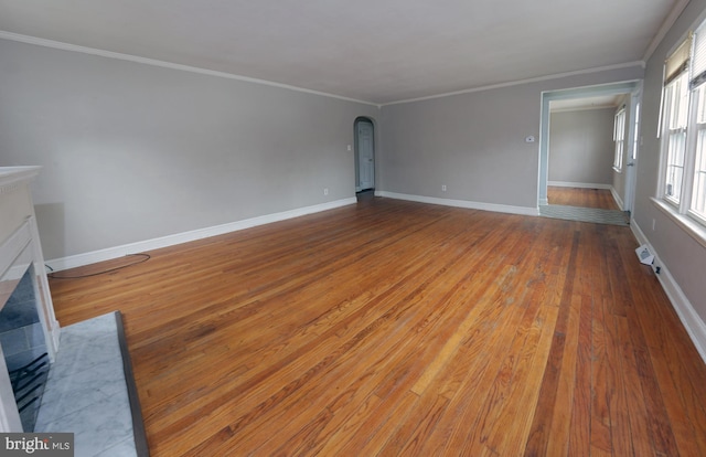 301 E Hanover St, Hanover, PA 17331 - unfurnished living room with a tiled fireplace, arched walkways, wood finished floors, and ornamental molding
