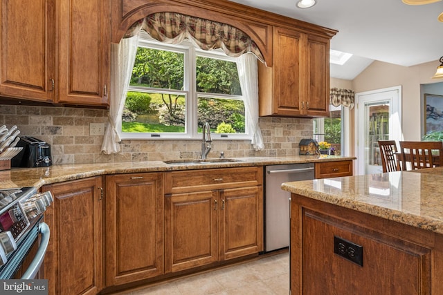 1043 Welsh Ayres Way, Downingtown, PA 19335 - kitchen with dishwasher, stove, vaulted ceiling, brown cabinetry, and light stone countertops