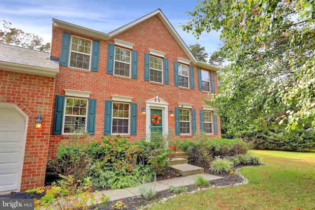 207 Weston Woods Dr, Pasadena, MD 21122 - colonial house featuring brick siding, a front lawn, and a garage
