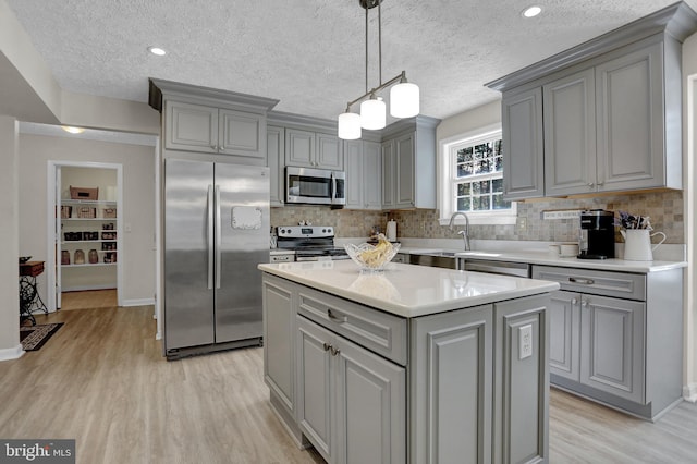 207 Weston Woods Dr, Pasadena, MD 21122 - kitchen with stainless steel appliances, gray cabinetry, light wood-style flooring, backsplash, and a textured ceiling