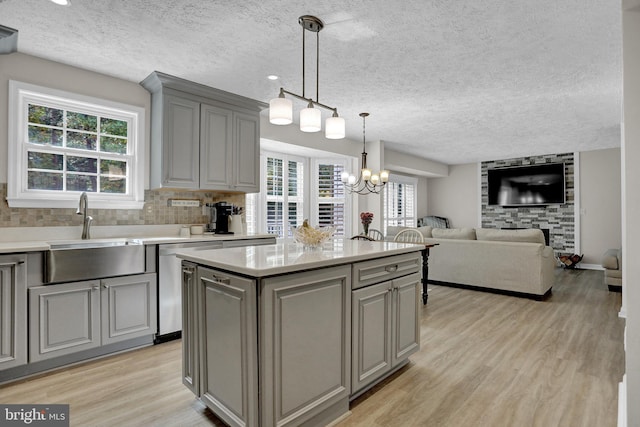 207 Weston Woods Dr, Pasadena, MD 21122 - kitchen with gray cabinetry, stainless steel dishwasher, light wood finished floors, light countertops, and a textured ceiling