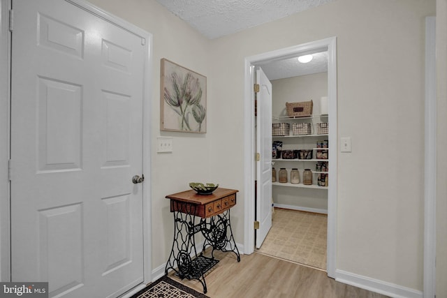 207 Weston Woods Dr, Pasadena, MD 21122 - hallway featuring a textured ceiling and wood finished floors