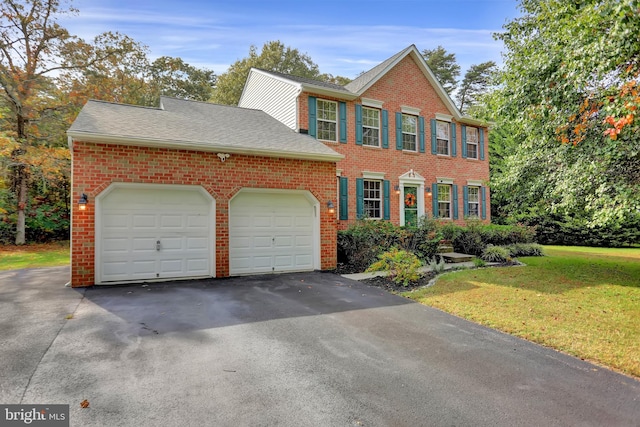 207 Weston Woods Dr, Pasadena, MD 21122 - colonial inspired home with brick siding, asphalt driveway, a garage, and a front lawn