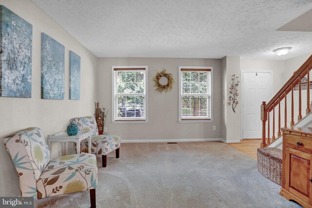 207 Weston Woods Dr, Pasadena, MD 21122 - sitting room with light colored carpet, a textured ceiling, and stairway