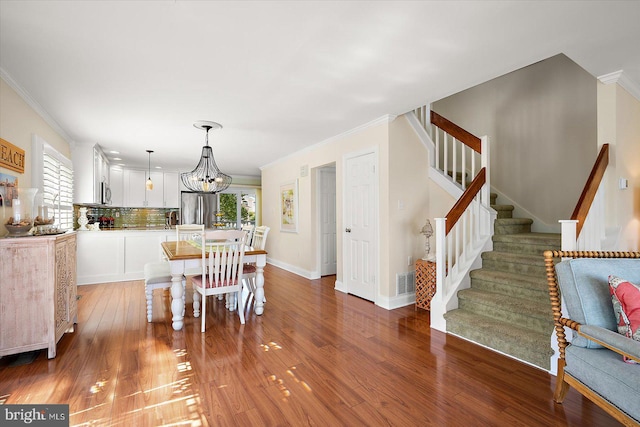 222 N Heron Dr Unit 222-1, Ocean City, MD 21842 - dining room featuring stairway, ornamental molding, light wood-type flooring, and a chandelier