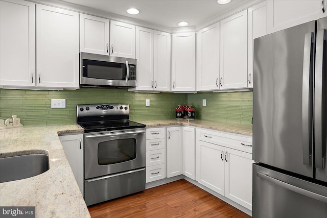 222 N Heron Dr Unit 222-1, Ocean City, MD 21842 - kitchen with stainless steel appliances, white cabinets, recessed lighting, and decorative backsplash