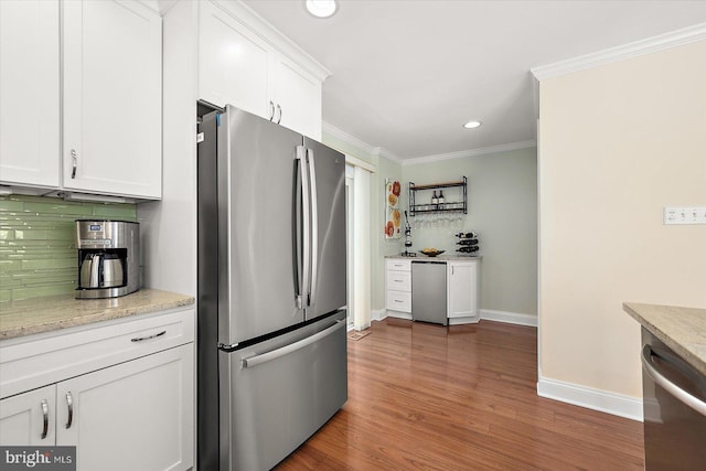 222 N Heron Dr Unit 222-1, Ocean City, MD 21842 - kitchen with stainless steel appliances, ornamental molding, white cabinets, decorative backsplash, and wood finished floors