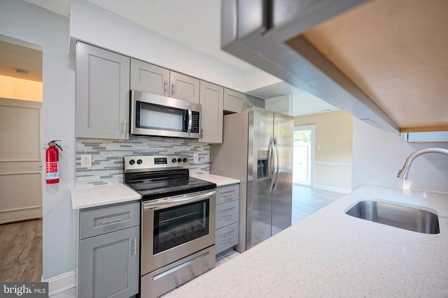 16 Franklin Dr, Voorhees, NJ 08043 - kitchen featuring appliances with stainless steel finishes, gray cabinetry, light wood finished floors, and tasteful backsplash