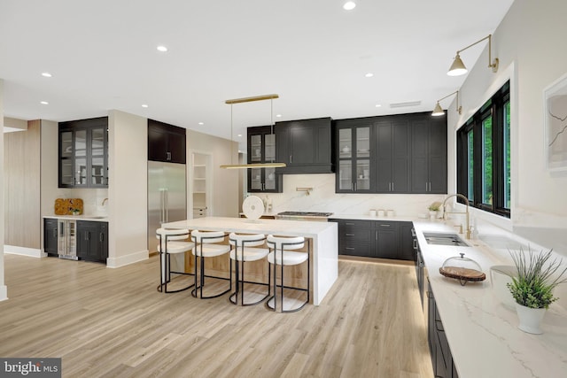 1710 Fairview Ave, Mclean, VA 22101 - kitchen featuring appliances with stainless steel finishes, light wood-style floors, decorative backsplash, a kitchen island, and recessed lighting