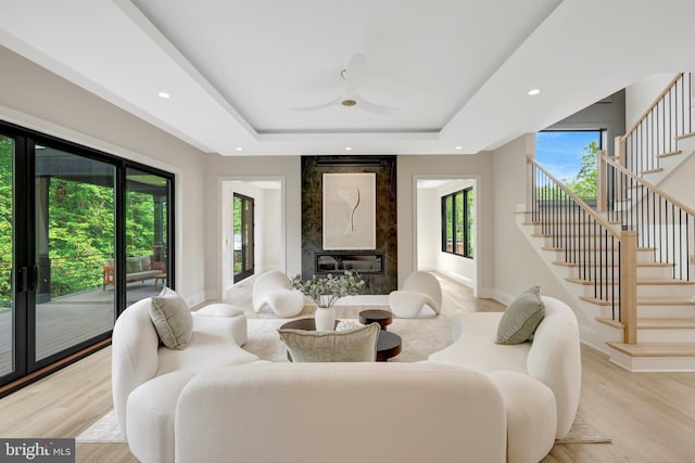 1710 Fairview Ave, Mclean, VA 22101 - living area with stairs, a raised ceiling, light wood finished floors, a ceiling fan, and a fireplace