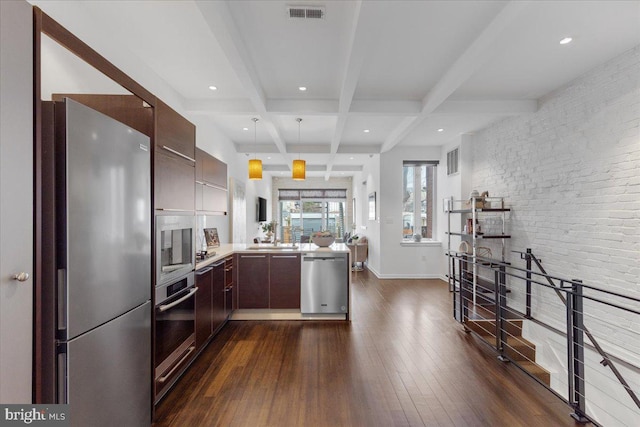 2223 1st St NW Unit 1, Washington, DC 20001 - kitchen featuring appliances with stainless steel finishes, dark wood-style flooring, beam ceiling, light countertops, and a peninsula