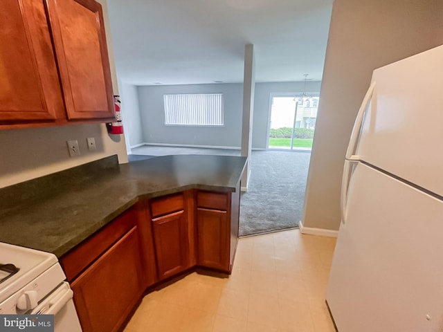 104 Falcon Ridge Way Unit Bldg10 Unit4, Hamburg, NJ 07419 - kitchen with freestanding refrigerator, light carpet, dark countertops, a peninsula, and brown cabinetry