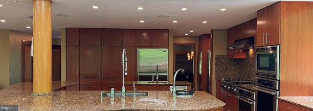 400 Highview Dr, Wayne, PA 19087 - kitchen featuring under cabinet range hood, built in appliances, modern cabinets, backsplash, and recessed lighting