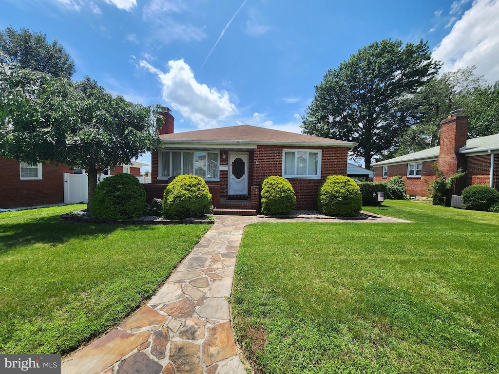 1814 Tyler Rd, Dundalk, MD 21222 - bungalow-style house with a front yard, brick siding, and a chimney