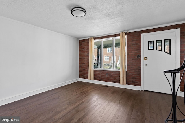 6333 Mershon St, Philadelphia, PA 19149 - foyer entrance featuring dark wood-style floors, brick wall, a textured ceiling, and crown molding
