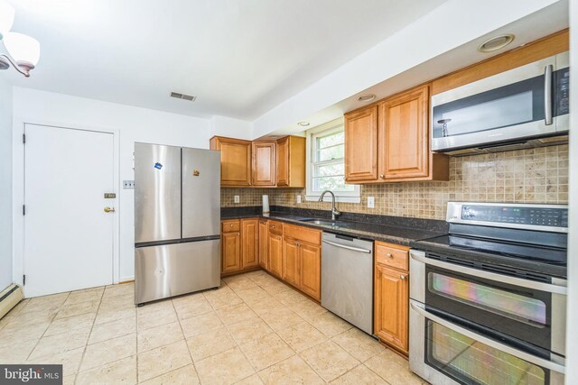 892 Timber Ridge Dr, Hanover, MD 21076 - kitchen featuring appliances with stainless steel finishes, backsplash, brown cabinets, and light tile patterned floors