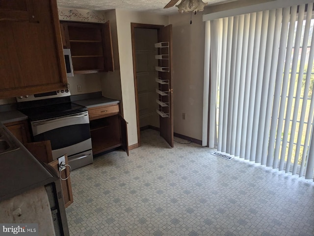 112 E 4th St, Seaford, DE 19973 - kitchen with appliances with stainless steel finishes, a ceiling fan, and brown cabinetry