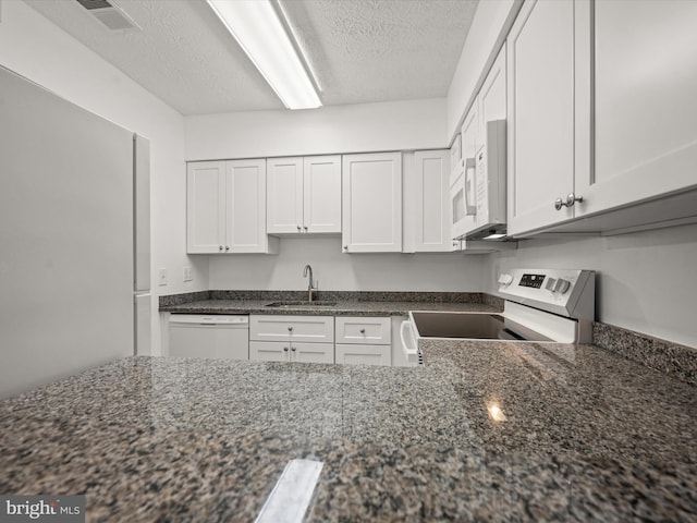 7607 Weather Worn Way Unit A, Columbia, MD 21046 - kitchen featuring white appliances, a textured ceiling, dark stone counters, and white cabinetry