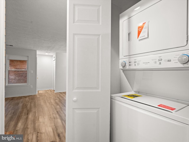 7607 Weather Worn Way Unit A, Columbia, MD 21046 - laundry room with stacked washer / drying machine, light wood finished floors, and a textured ceiling