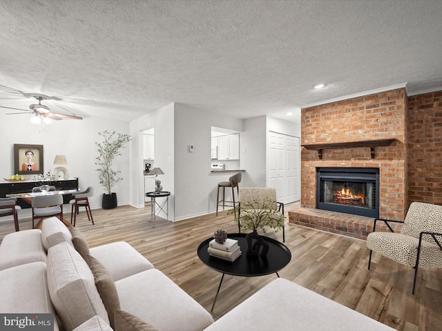 7607 Weather Worn Way Unit A, Columbia, MD 21046 - living room with a fireplace, a ceiling fan, wood finished floors, a textured ceiling, and recessed lighting