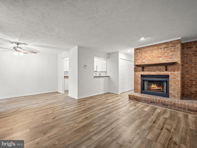 7607 Weather Worn Way Unit A, Columbia, MD 21046 - unfurnished living room featuring a textured ceiling, ceiling fan, a brick fireplace, wood finished floors, and recessed lighting