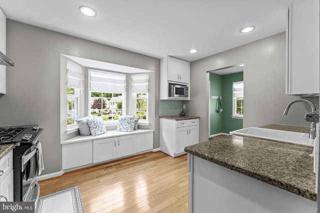 10034 Park Woods Ln, Burke, VA 22015 - kitchen featuring appliances with stainless steel finishes, white cabinets, light wood finished floors, recessed lighting, and dark stone counters