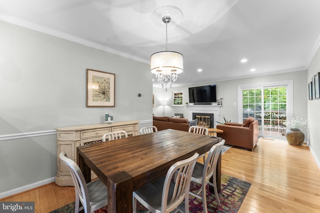 10034 Park Woods Ln, Burke, VA 22015 - dining room with a glass covered fireplace, crown molding, light wood-type flooring, a chandelier, and recessed lighting