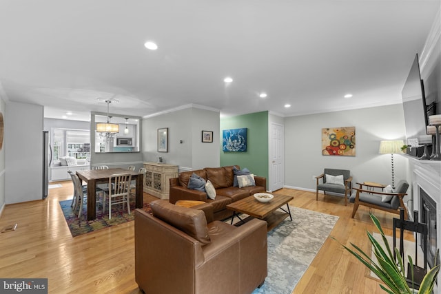 10034 Park Woods Ln, Burke, VA 22015 - living room with recessed lighting, a fireplace, ornamental molding, light wood-style flooring, and a chandelier