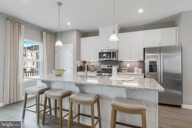 13626 Corinthian Ln Unit D-F02006D, Brandywine, MD 20613 - kitchen featuring stainless steel appliances, tasteful backsplash, light wood-type flooring, white cabinets, and an island with sink