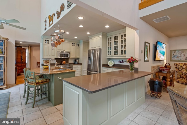 4 Surrey Rd, Rehoboth Beach, DE 19971 - kitchen with appliances with stainless steel finishes, a breakfast bar area, light tile patterned floors, a ceiling fan, and recessed lighting