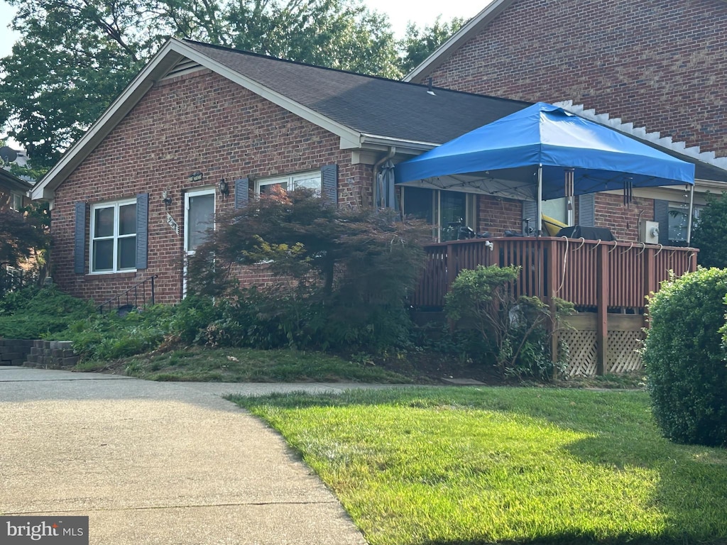 9573 Hagel Cir Unit 15/A, Lorton, VA 22079 - view of home's exterior featuring brick siding, a lawn, and a wooden deck