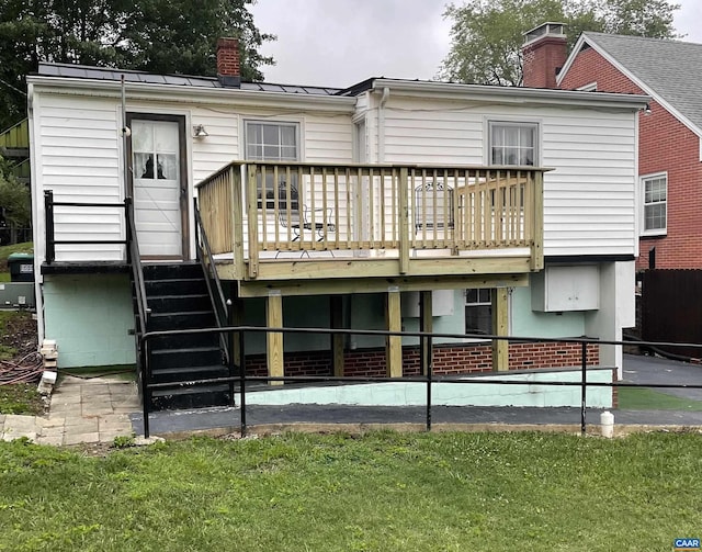 2504 Plateau Rd, Charlottesville, VA 22903 - back of property with a chimney, a wooden deck, a standing seam roof, a metal roof, and a lawn