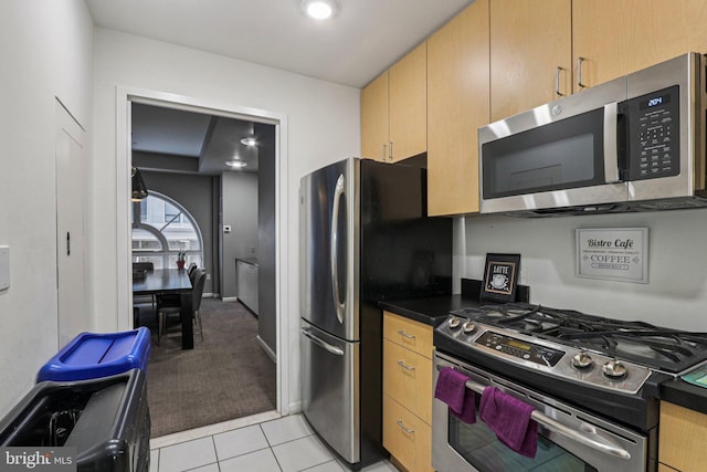 1425 Locust St Unit 7D, Philadelphia, PA 19102 - kitchen with stainless steel appliances, dark countertops, light tile patterned flooring, and light colored carpet