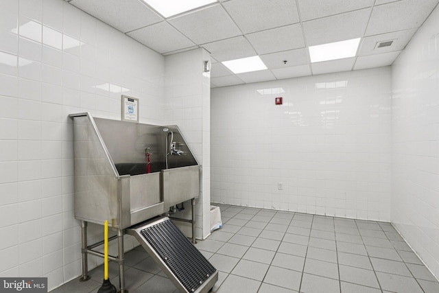 1425 Locust St Unit 7D, Philadelphia, PA 19102 - misc room featuring pet washing station, tile walls, light tile patterned floors, and a paneled ceiling