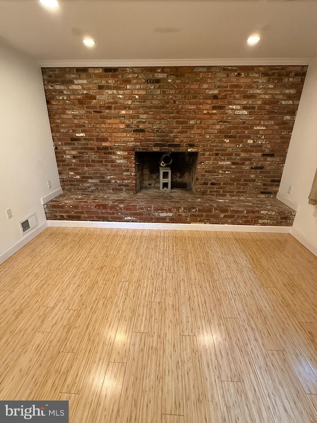 7400 Roxbury Ave, Manassas, VA 20109 - unfurnished living room with wood finished floors, a fireplace, brick wall, and recessed lighting