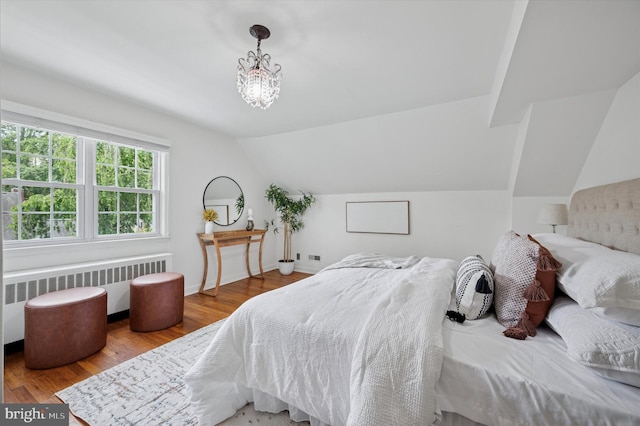 12 Rodney Rd, Bryn Mawr, PA 19010 - bedroom with radiator heating unit, vaulted ceiling, wood finished floors, and a chandelier