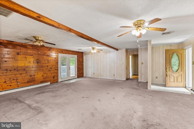 26140 High Banks Dr, Salisbury, MD 21801 - unfurnished living room featuring a ceiling fan, french doors, a textured ceiling, wood walls, and carpet