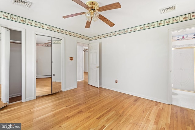 26140 High Banks Dr, Salisbury, MD 21801 - unfurnished bedroom featuring two closets, wood-type flooring, ensuite bathroom, a baseboard heating unit, and a ceiling fan