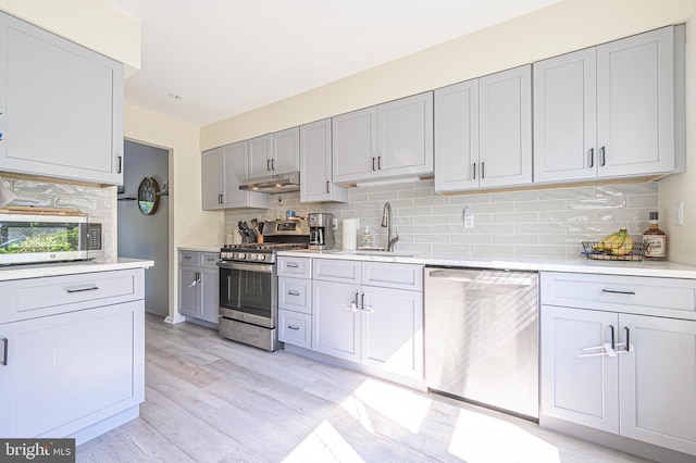 39 Allison Pl, Egg Harbor Township, NJ 08234 - kitchen with stainless steel appliances, light wood-style floors, decorative backsplash, under cabinet range hood, and light countertops