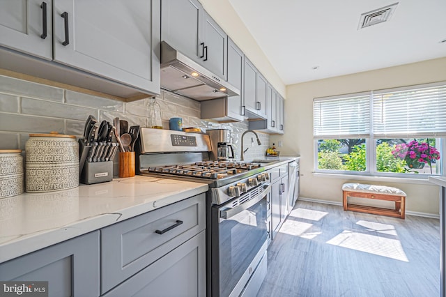39 Allison Pl, Egg Harbor Township, NJ 08234 - kitchen featuring stainless steel gas range oven, under cabinet range hood, gray cabinets, light stone counters, and light wood finished floors