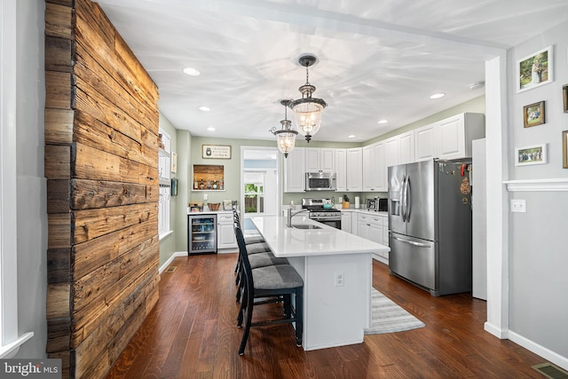 4334 Mitchell St, Philadelphia, PA 19128 - kitchen featuring stainless steel appliances, wine cooler, light countertops, white cabinetry, and dark wood finished floors