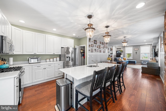 4334 Mitchell St, Philadelphia, PA 19128 - kitchen with stainless steel appliances, light countertops, open floor plan, dark wood finished floors, and white cabinets