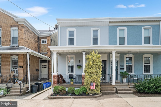 4334 Mitchell St, Philadelphia, PA 19128 - townhome / multi-family property with covered porch, stucco siding, and brick siding